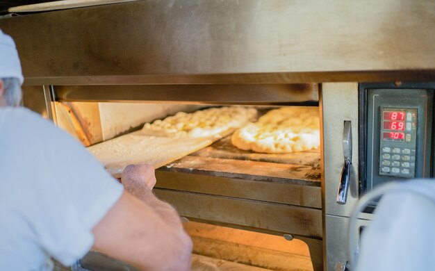 Padeiros assam pizza romana tradicional no início da manhã padaria tradicional