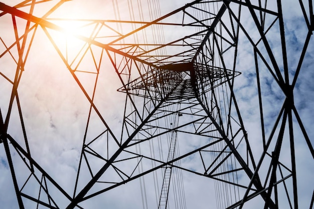 Padrão abstrato da vista inferior da torre de transmissão de energia de poste de alta tensão com fundo de dia ensolarado de céu claro Conceito de conservação ambiental de energia verde