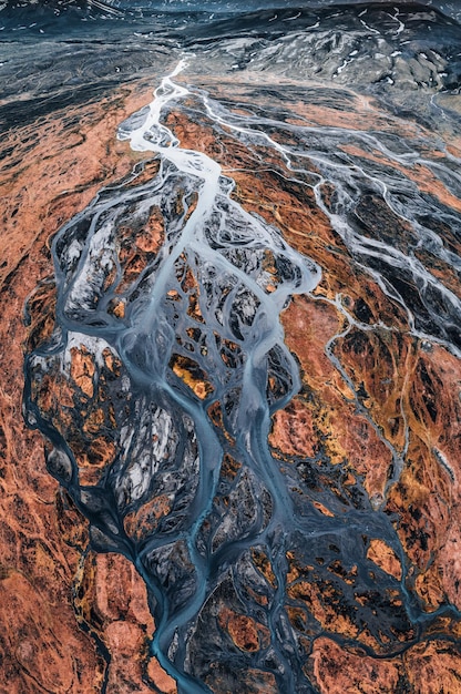 Padrão abstrato de rios glaciares fluindo através do campo de lava vulcânica nas terras altas da Islândia no verão