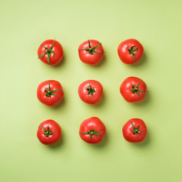 Padrão criativo de tomates vermelhos em fundo verde Vista de cima Copiar espaço Design minimalista Comida orgânica vegana vegetariana e conceito de refeição alcalina