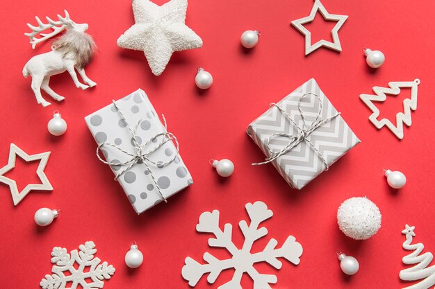 Padrão de decorações de Natal brancas, presentes, enfeites, veados, flocos de neve no espaço vermelho