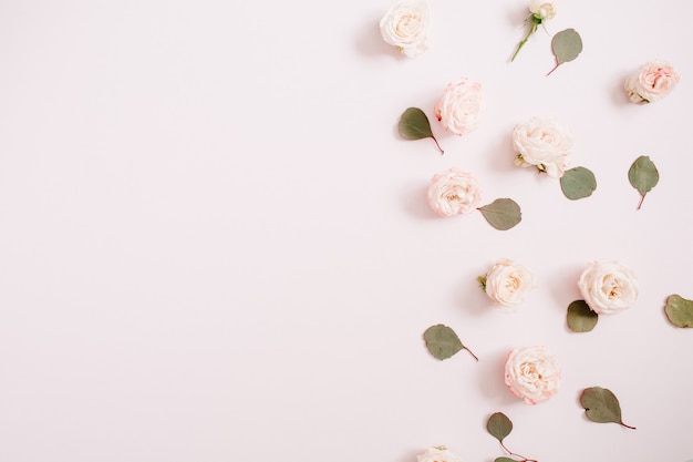 Padrão de flores feito de rosas bege, galhos de eucalipto em rosa pastel claro