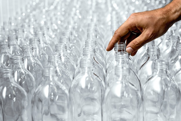 Padrão de garrafas de vidro transparente com uma mão no processo de fazer a bebida saudável