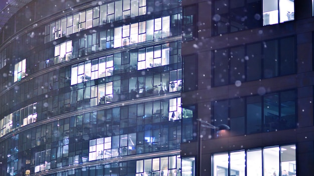 Padrão de janelas de prédios de escritórios iluminadas à noite Edifício corporativo de arquitetura de vidro em
