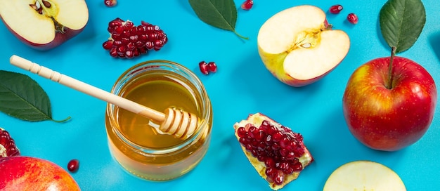 Padrão de maçãs mel e romãs em fundo azul Feliz Rosh Hashanah feriado religioso judaico Formato de banner