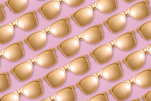 Padrão de óculos de sol dourados em fundo rosa