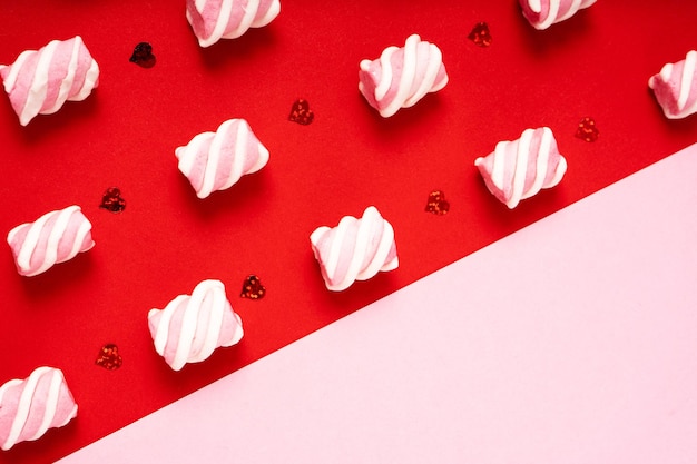 Padrão de pequenos marshmallows em um fundo vermelho e uma parte vazia rosa para espaço de cópia