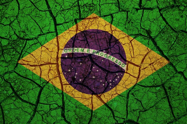 Foto padrão de solo seco na bandeira do brasil. país com conceito de seca. problema da água. rachado a seco