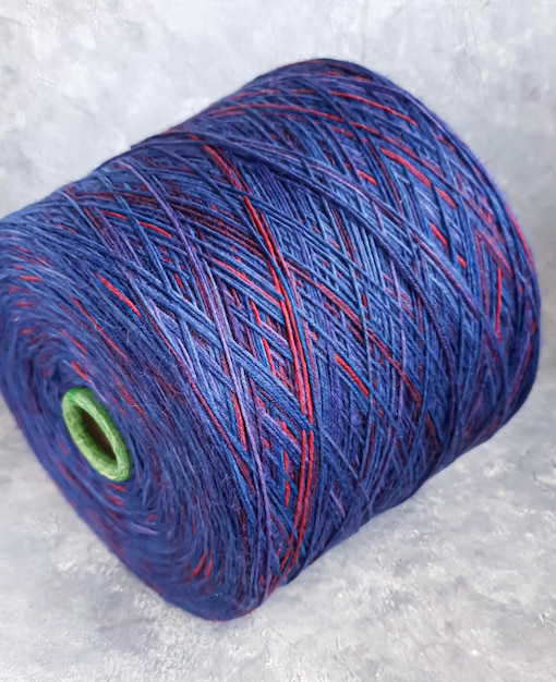Padrão de tricô feito à mão Tecido de malha de um fio multicolorido e uma bobina grande