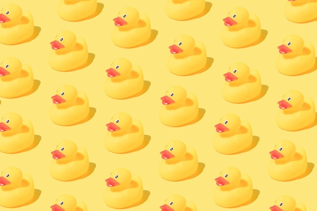 Foto padrão feito de patos de banho de borracha em fundo amarelo copiar espaço