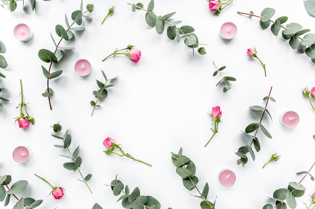 Padrão floral feito de rosas cor de rosa folhas verdes galhos de eucalipto sobre fundo branco plano plano