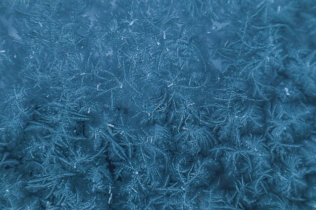 Padrão gelado em tons azuis no vidro da janela em um dia de inverno