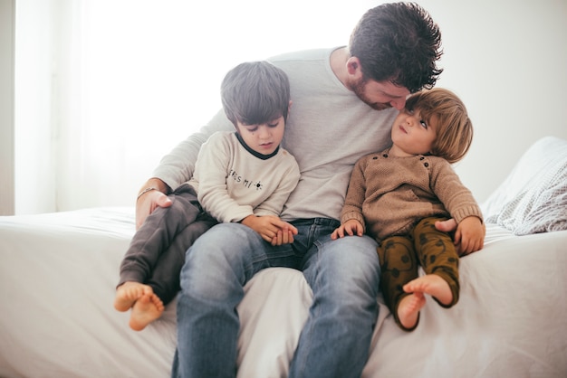 Padre abrazando a hijos pequeños