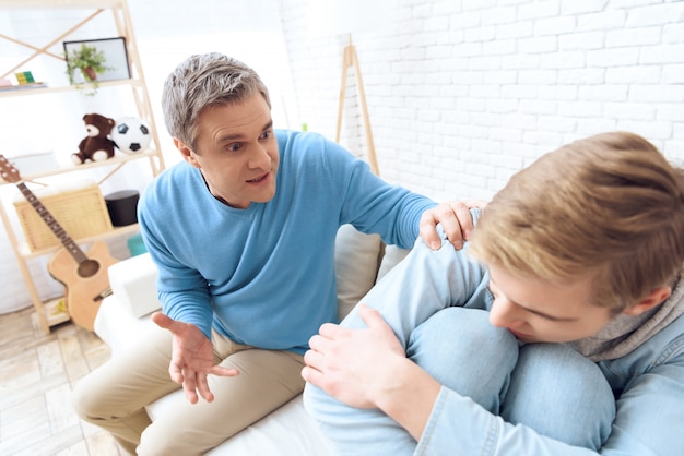 Padre se acerca con su mano infeliz hijo.