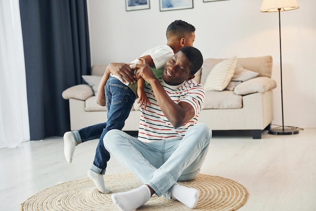 Padre afroamericano de familia feliz con su hijo pequeño en casa