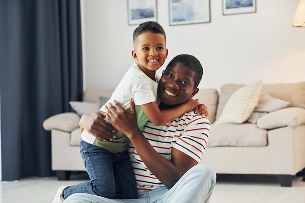 Padre afroamericano de familia feliz con su hijo pequeño en casa