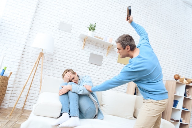 Foto el padre agita el cinturón para golpear a su hijo.