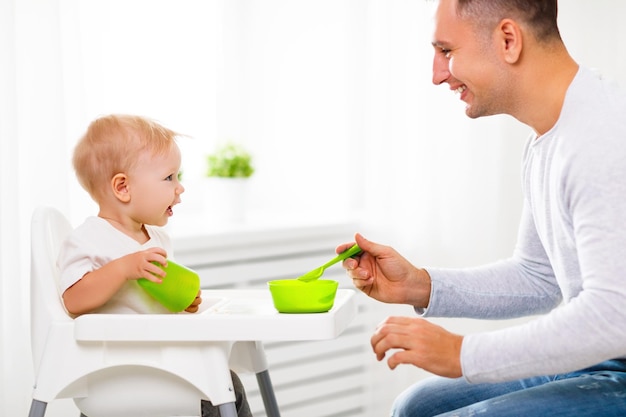 El padre alimenta al bebé con una cuchara