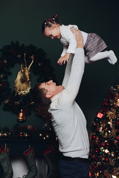 Padre amoroso jugando con su hija en Navidad.