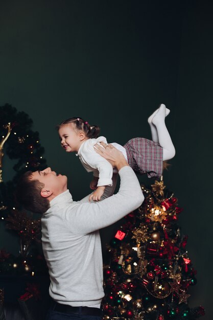 Padre amoroso jugando con su hija en Navidad.