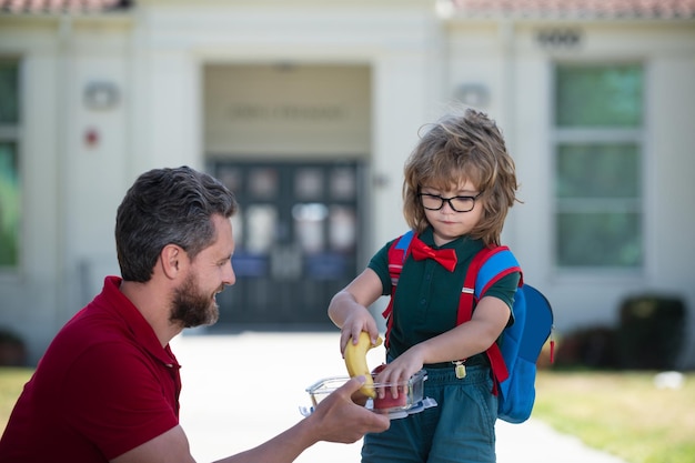 Foto el padre apoya y motiva al hijo del niño que va a la escuela primaria.