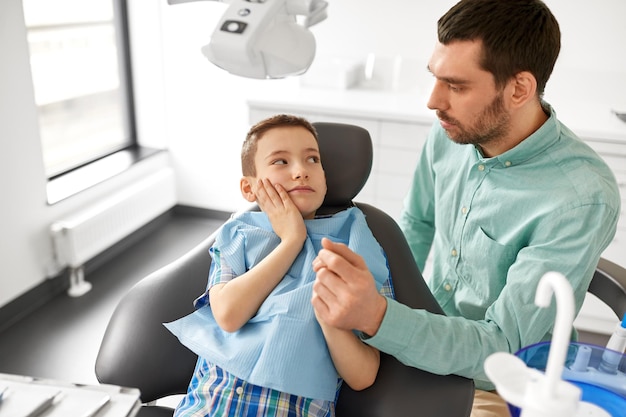 padre apoyando a su hijo en la clínica dental