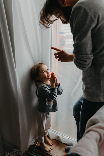 El padre arrincona al niño y hace comentarios por mal comportamiento moviendo su dedo índice cerca de su cara El niño no quiere castigo y se disculpa