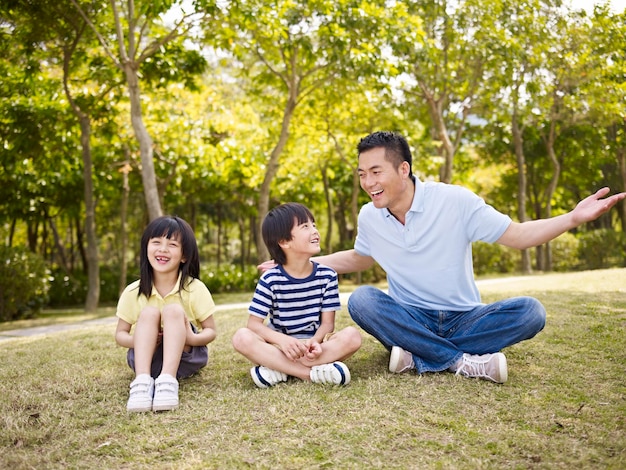 Foto padre asiático e hijos teniendo una conversación interesante