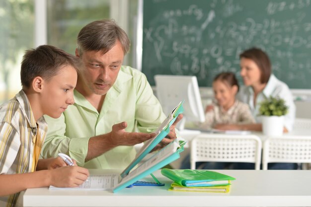 Padre ayudando a su hijo a hacer la tarea en el aula