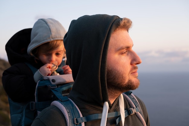 Foto padre con el bebé de espaldas contra el cielo