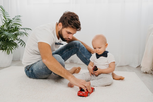 Foto padre y bebé jugando juntos en casa