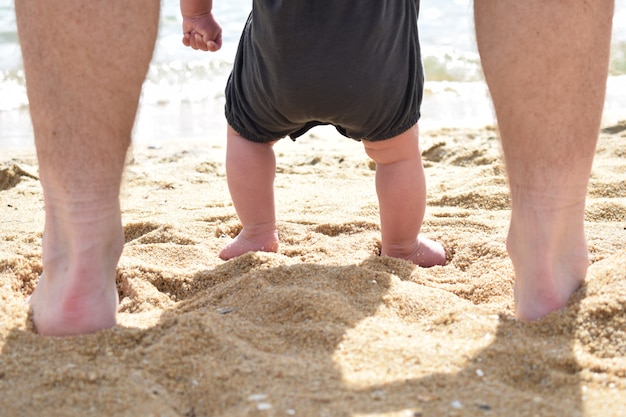 Padre y bebé en la playa por primera vez