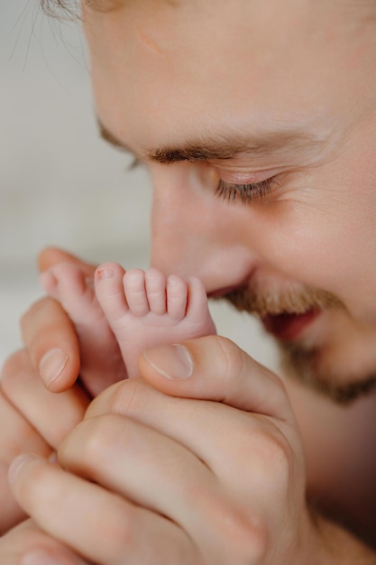 Padre besa la pierna del bebé Amor por el niño