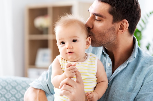 padre besando a su pequeña hija