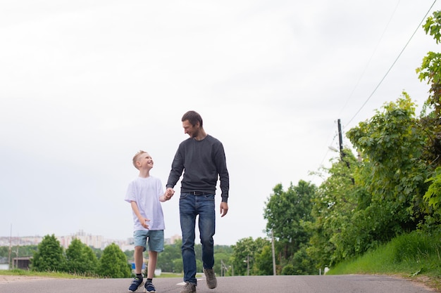 Un padre camina con su hijo en el camino El niño se está complaciendo