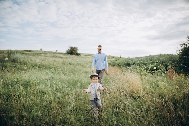 Padre caminando en el campo con su pequeño hijo