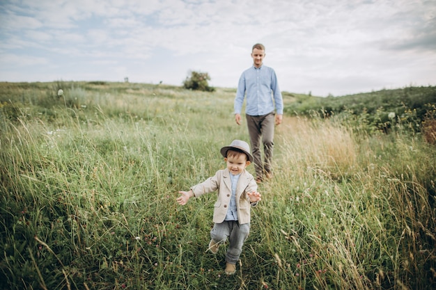 Padre caminando en el campo con su pequeño hijo