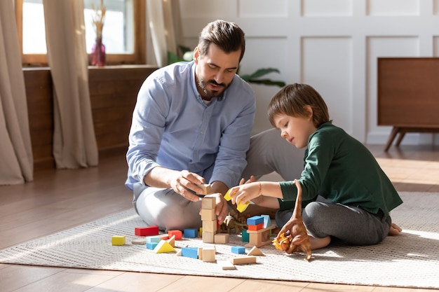 El padre cariñoso se divierte jugando con el hijo pequeño