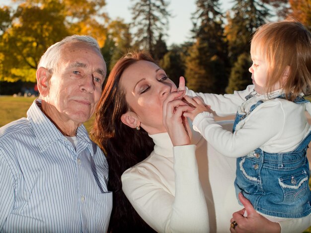 Padre compartiendo un momento de felicidad con su hija y nieta.