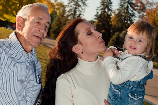 Padre compartiendo un momento de felicidad con su hija y nieta.