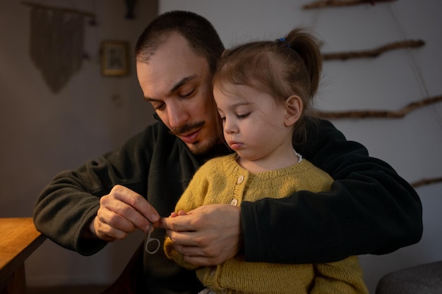 Foto padre cortando las uñas de su hija