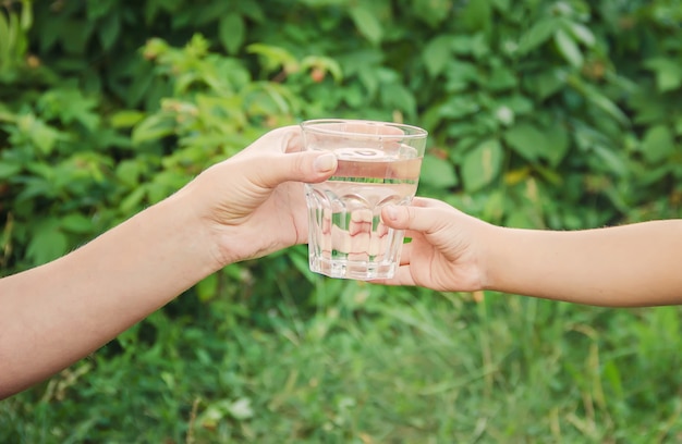 El padre le da al niño un vaso de agua. Enfoque selectivo