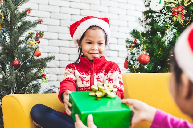 Padre dando caja de regalo de Navidad a linda niña asiática en celebración de Navidad