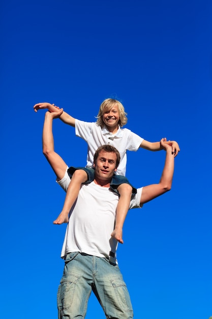 Padre dando a su hijo a cuestas