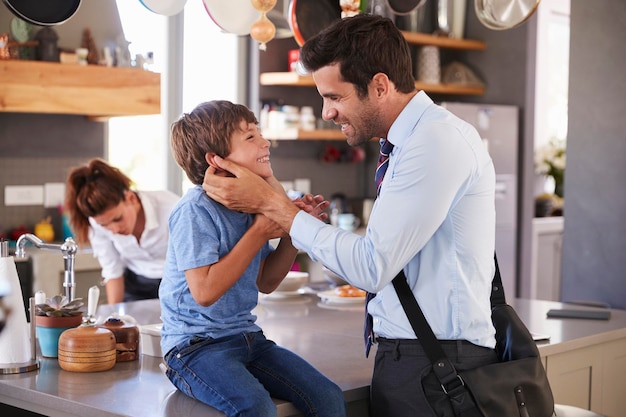 Padre diciendo adiós a su hijo mientras se va al trabajo