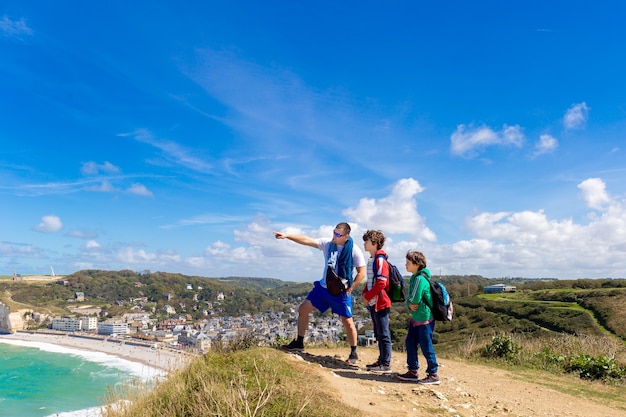 Padre y dos hijos viajan juntos y hacen senderismo en las pintorescas montañas. Concepto de turismo familiar