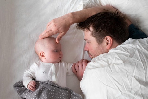 Padre durmiente y niño lindo descansando juntos en la cama.