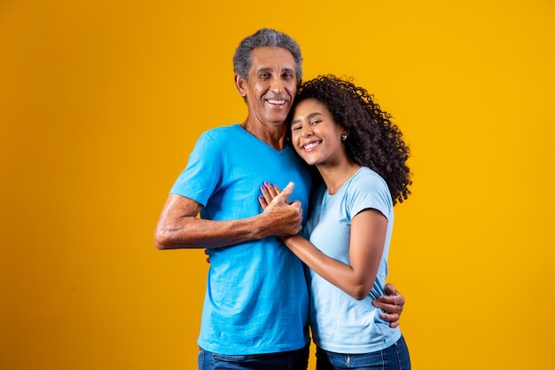 Padre e hija afro sonriendo sobre fondo amarillo. concepto del día del padre