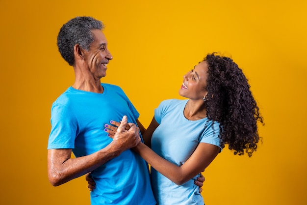Padre e hija afro sonriendo sobre fondo amarillo. concepto del día del padre