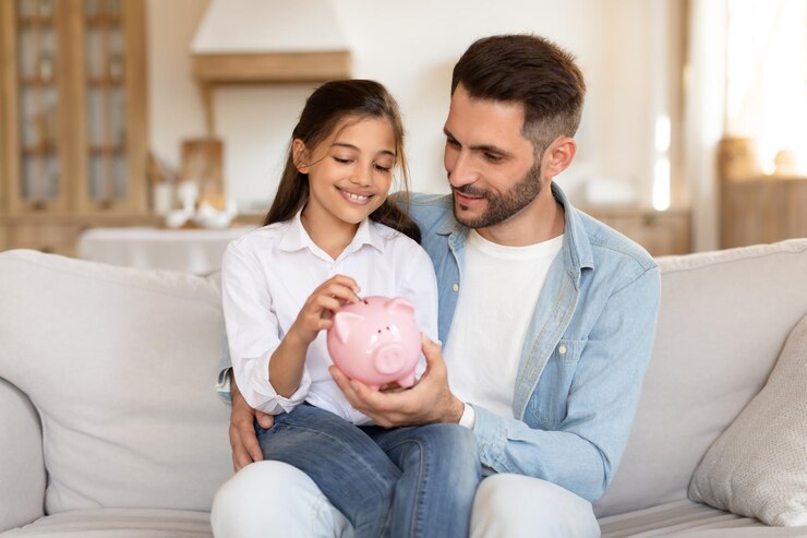 Padre e hija ahorrando dinero juntos en casa.